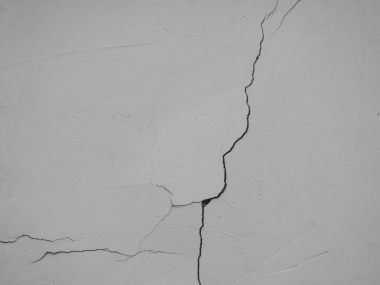 Structural crack running through a painted plaster wall
