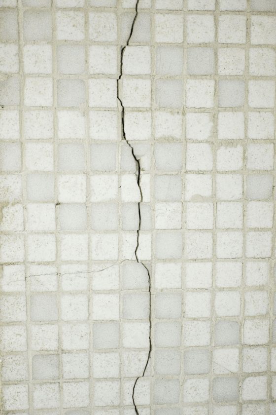 Crack running across white mosaic floor tiles